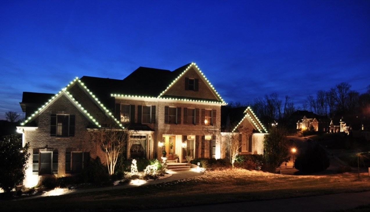 Large brick home decorated with professional Christmas roofline lighting